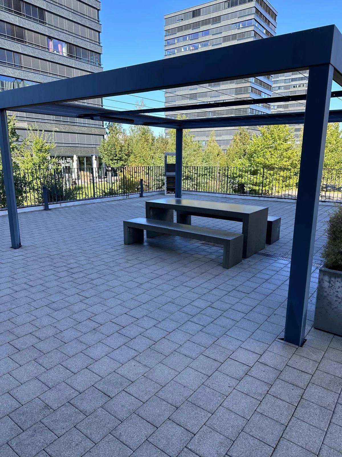 Saubere Gemeinschaftsterrasse mit Pergola und Sitzbank einer Wohnüberbauung